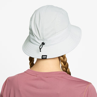 back view of ciele athletics GOBucket Comp Athletics unisex running bucket hat in light grey color on a model