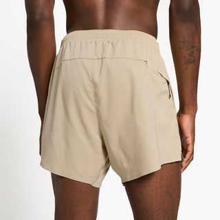 close back view of ciele athletics ATShort 5 inch with liner short in safari color on a model