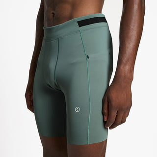 back view of ciele athletics FSTTight 8 inch short running tight in silver pine on a model