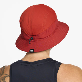 back view of ciele athletics GOBucket Comp Athletics unisex running bucket hat in clay color on a model