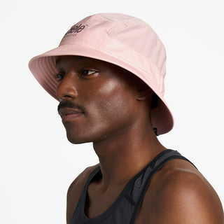 side view of ciele athletics GOBucket Comp Athletics unisex running buckethat in peachskin color on a model