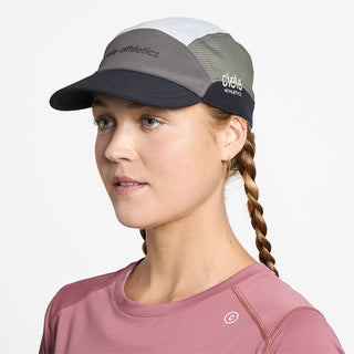 side view of ciele athletics FSTCap SC Field Iconic SL unisex running hat in whitaker color on a model