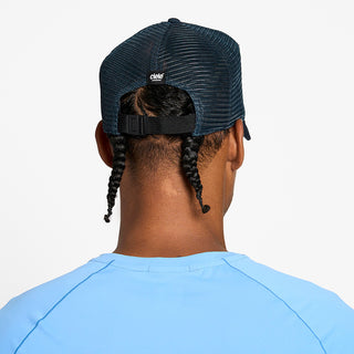 back view of the ciele athletics TRLCap unisex running hat with a curved brim in deep space color, on a model
