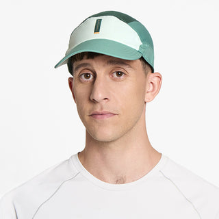 front view of ciele athletics FSTCap SC Comp Iconic VC unisex running hat in dusty turquoise emerald color on a model