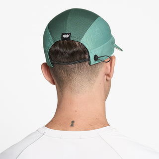 back view of ciele athletics FSTCap SC Comp Iconic VC unisex running hat in dusty turquoise emerald color on a model