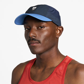 side view of ciele athletics GOCap Comp C cube unisex running hat in indigo color on a model