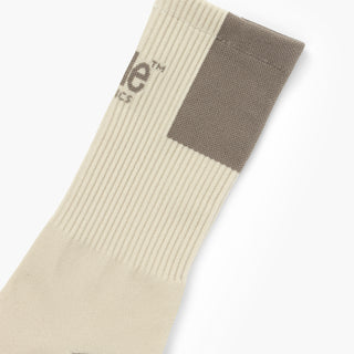 elastic of beige sock with brown patch on a white background