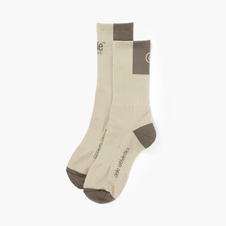 pair of beige color socks with brown accents on a white background