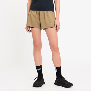 person wearing tan athletic shorts and black socks on a white background