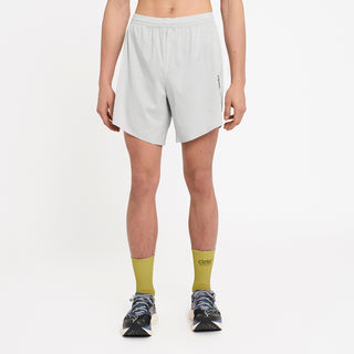 person wearing light gray athletic shorts and green socks on a white background