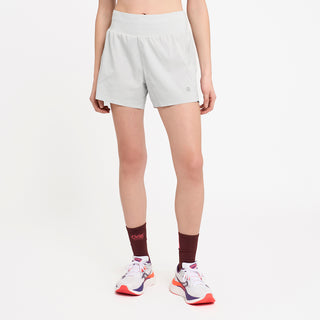 person wearing light gray athletic shorts and brick socks on a white background