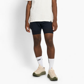 person wearing navy athletic shorts and white socks on a white background